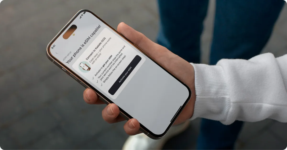 Hand holding a phone with eSIM setup screen - Kastelo GIGS